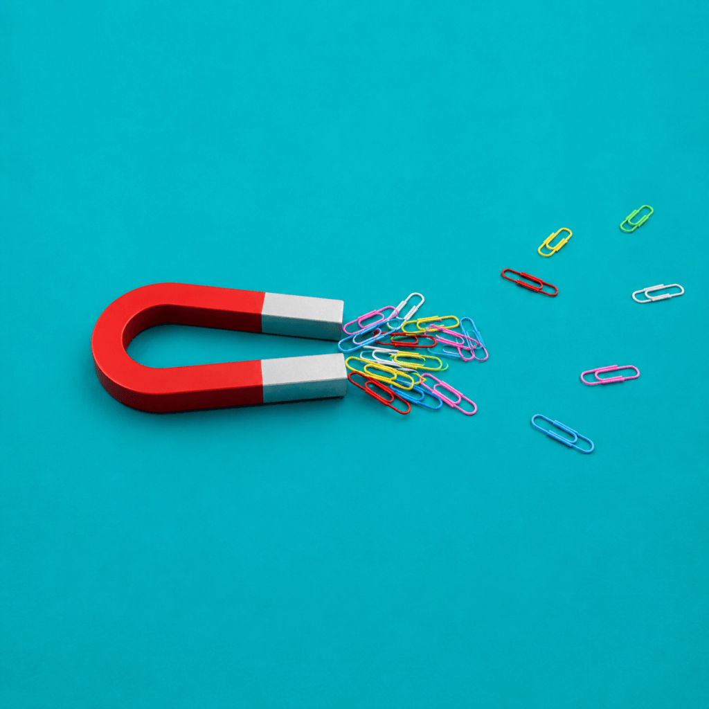 Task Management for ADHD: Systems Built for How Your Brain Works - single horseshoe magnet gathering scattered colorful paperclips into a neat cluster