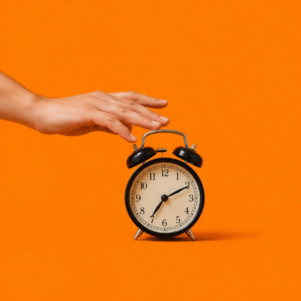 Akrasia: Why You Act Against Your Own Best Judgment (And What Helps) - single alarm clock with a hand reaching to hit snooze in mid-motion