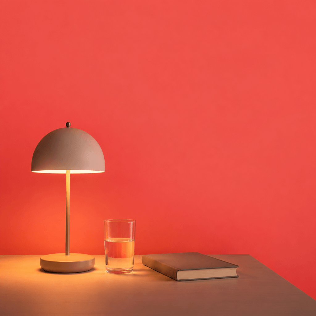 Evening Routine for Productivity: How to Wind Down and Wake Up Ready to Perform - single bedside lamp dimmed low beside a closed book and glass of water