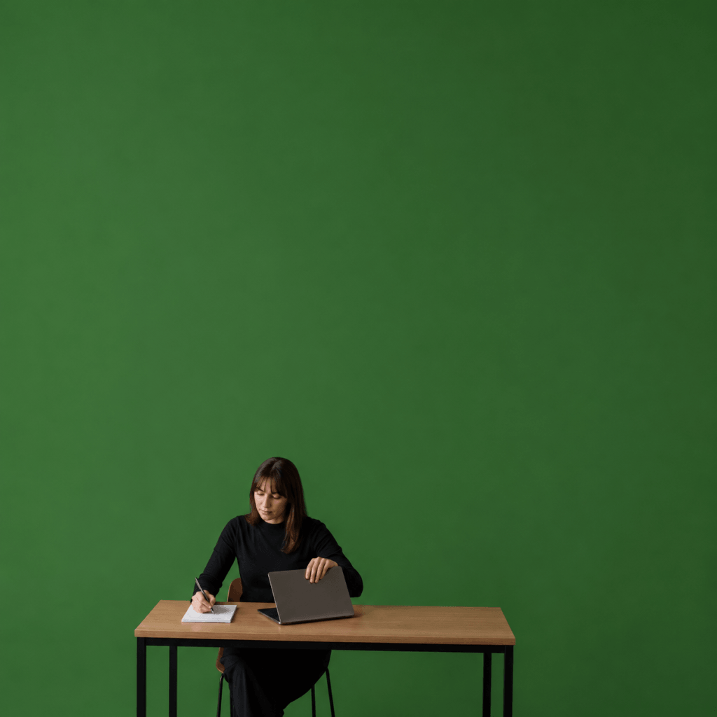 Weekly Review Template (Free PDF): 4 Prompts, 5 Minutes - person closing a laptop and writing three short lines on a paper pad