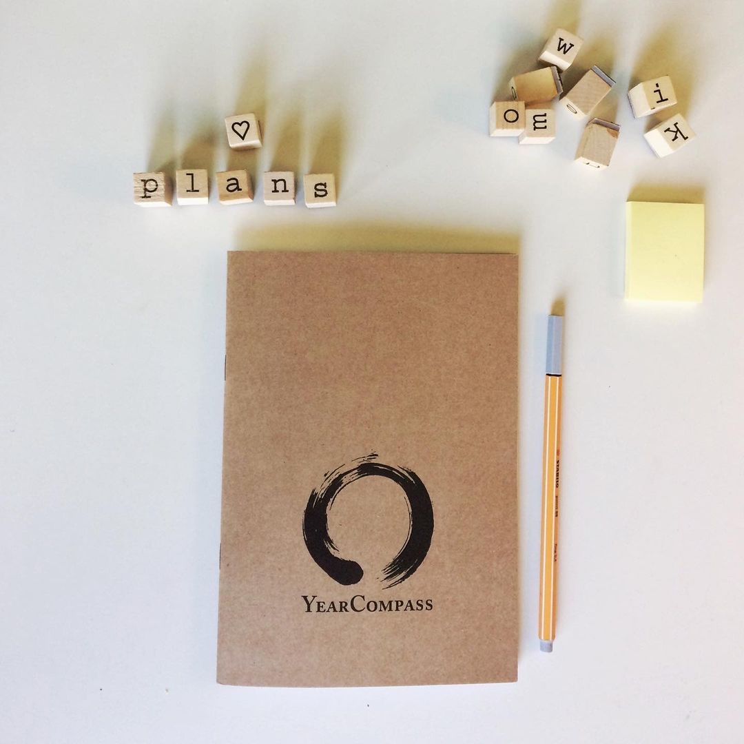 Best Goal Planners for 2027: Paper, Tablet and App 10 Printed YearCompass booklet cover on a desk